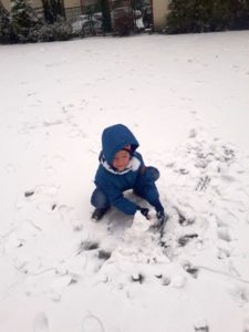 Chłopiec bawi się w śniegu